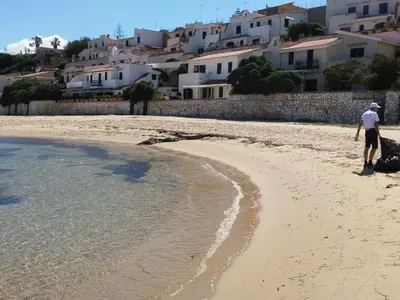 a man walking on a beach with a dog at Apartment Villa am Meer Trappeto by Interhome in Trappeto