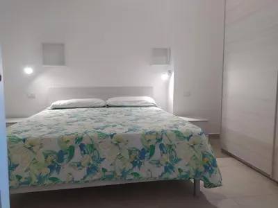 a bedroom with a bed with a floral bedspread at Apartment Ferienhäuser Small App- für 5 in Balestrate by Interhome in Balestrate