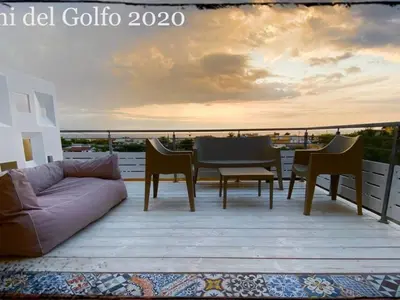 a living room with a couch and a table on a balcony at Apartment Wohnung GIallo mit Schwimmbad und Meerblick by Interhome in Balestrate