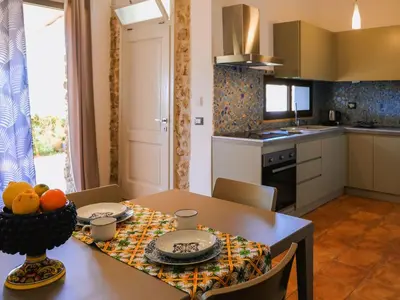 a kitchen with a dining table and a kitchen with a table and chairs at Apartment Wohnung GIallo mit Schwimmbad und Meerblick by Interhome in Balestrate