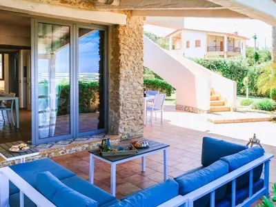 a patio with a blue couch and a table at Apartment Wohnung in Balestrate mit Schwimmbad und Meerblick by Interhome in Balestrate