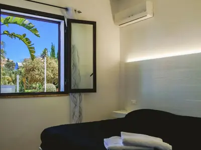 a bedroom with a window and a bed with towels at Apartment Wohnung in Balestrate mit Schwimmbad und Meerblick by Interhome in Balestrate