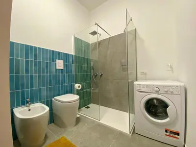 a bathroom with a toilet and a washing machine at Apartment Casa La Mamà- Strand 150 m entfernt by Interhome in Alcamo