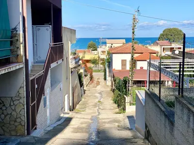 an alley in a town with the ocean in the background at Apartment Casa La Mamà- Strand 150 m entfernt by Interhome in Alcamo