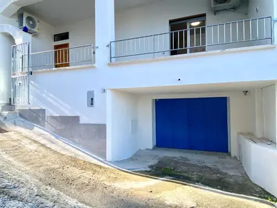 a garage with a blue door on the side of a building at Apartment Casa La Mamà- Strand 150 m entfernt by Interhome in Alcamo