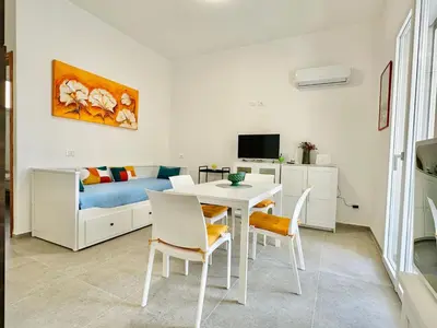 a living room with a table and chairs and a bed at Apartment Casa La Mamà- Strand 150 m entfernt by Interhome in Alcamo