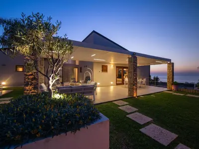 a house with a view of the ocean at night at Holiday Home Villa in Sizilien am Meer mit beheiztem Pool by Interhome in Alcamo Marina
