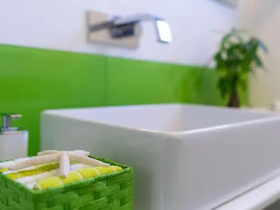 a bathroom with a white toilet and a green wall at Holiday Home Villa in Sizilien am Meer mit beheiztem Pool by Interhome in Alcamo Marina