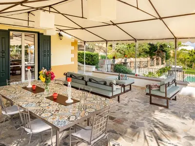 a patio with tables and chairs and a couch at Holiday Home Villa Tommaso Maruggi Jacuzzi und privater Pool by Interhome in Alcamo