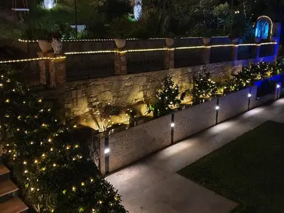 a garden with lights on a stone wall at Holiday Home Villa Tommaso Maruggi Jacuzzi und privater Pool by Interhome in Alcamo
