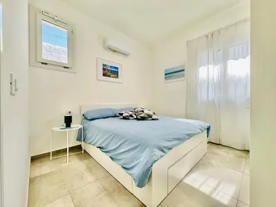 a white bedroom with a bed and a window at Apartment Sea Life Giulia- 200 m vom Strand entfernt by Interhome in Alcamo Marina