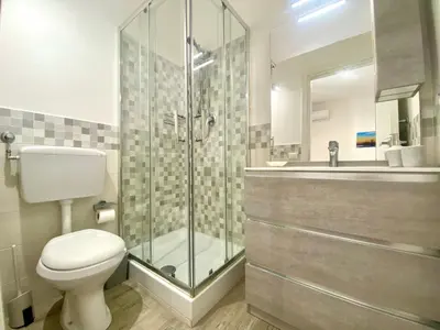 a bathroom with a shower and a toilet and a sink at Apartment GS Urlaub del Golfo Haus mit Jacuzzi by Interhome in Castellammare del Golfo