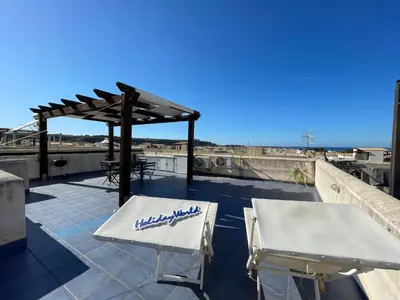 a patio with two white chairs and a pergola at Apartment Casa Sterlizia bei Holiday World by Interhome in San Vito lo Capo
