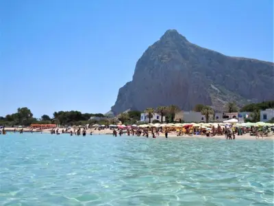 a group of people on a beach with a mountain in the background at Apartment Casa Sterlizia bei Holiday World by Interhome in San Vito lo Capo
