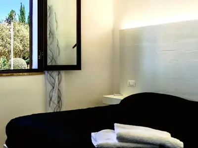 a bedroom with a bed and a window with towels at Apartment Wohnung Glicine mit Schwimmbad und Meerblick by Interhome in Balestrate