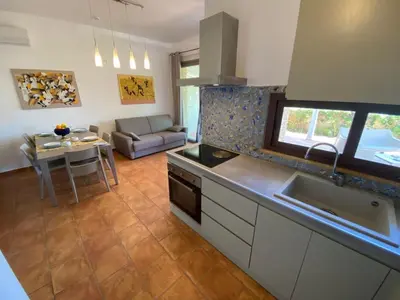 a kitchen with a couch and a table in a room at Apartment Wohnung Glicine mit Schwimmbad und Meerblick by Interhome in Balestrate