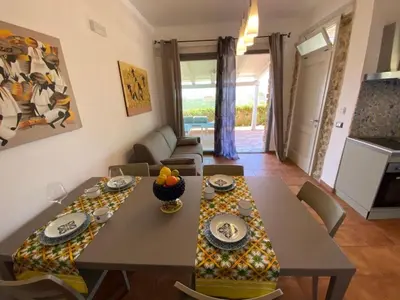 a living room with a table and a dining room at Apartment Wohnung Glicine mit Schwimmbad und Meerblick by Interhome in Balestrate