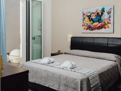 a bedroom with a bed and a painting on the wall at Holiday Home Haus in Balestrate mit privatem Parkplatz by Interhome in Balestrate