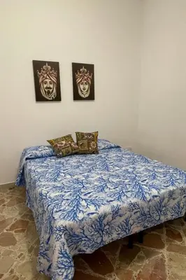 a bed in a bedroom with three pictures on the wall at Apartment Wohnung maestrale Sizilien home by Interhome in Balestrate