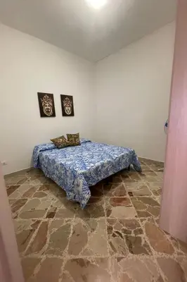 a bedroom with a bed in the corner of a room at Apartment Wohnung maestrale Sizilien home by Interhome in Balestrate