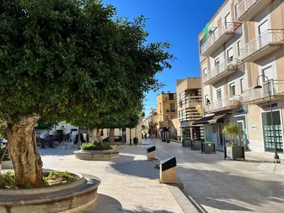 a street in a city with a tree and buildings at Holiday Home Villa Panorama del Golfo mit privatem Pool und Grillplatz by Interhome in Balestrate