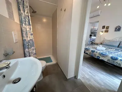 a bathroom with a sink and a bedroom with a bed at Holiday Home Villa Oasi- 50 m vom Strand entfernt- klimatisiert by Interhome in Alcamo