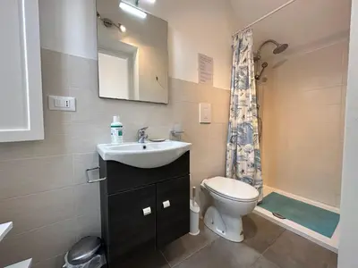 a bathroom with a sink and a toilet and a mirror at Holiday Home Villa Oasi- 50 m vom Strand entfernt- klimatisiert by Interhome in Alcamo