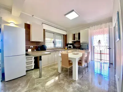 a kitchen with a table and a white refrigerator at Holiday Home Villa Grace- Strand 200 m entfernt by Interhome in Alcamo