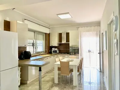a kitchen with white cabinets and a table and chairs at Holiday Home Villa Grace- Strand 200 m entfernt by Interhome in Alcamo