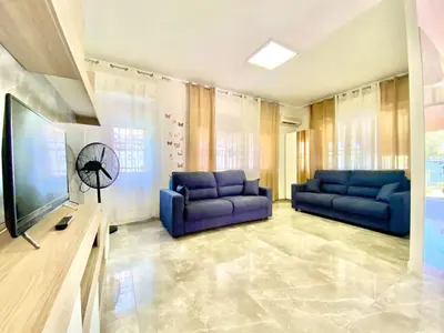 a living room with two blue couches and a television at Holiday Home Villa Grace- Strand 200 m entfernt by Interhome in Alcamo