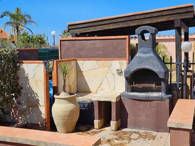 a outdoor pizza oven with a plant in a vase at Holiday Home Villa mit Wasserblick by Interhome in Campofelice di Roccella
