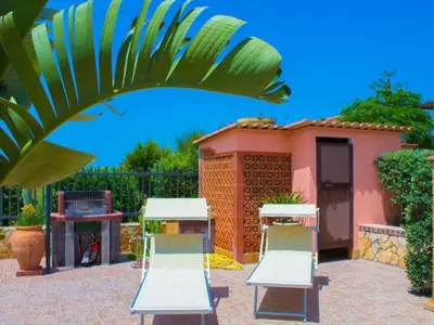 two chairs and a grill in front of a house at Holiday Home Ferienvilla mit Wasserblick by Interhome in Campofelice di Roccella