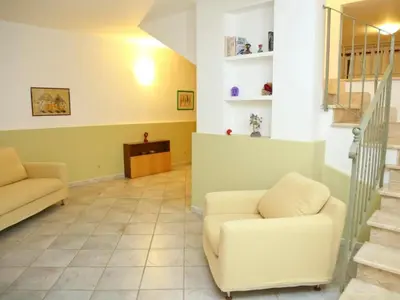 a living room with two chairs and a staircase at Holiday Home Ferienvilla mit Wasserblick by Interhome in Campofelice di Roccella