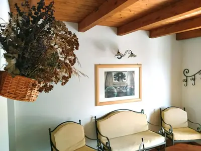 a waiting room with two chairs and a flower basket on the wall at Holiday Home Manderino-Panoramasuite mit Park und Pool by Interhome in Santa Flavia
