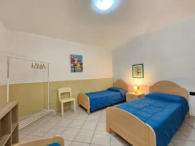 a bedroom with two beds and a table and chairs at Holiday Home Villa mit Wasserblick by Interhome in Campofelice di Roccella