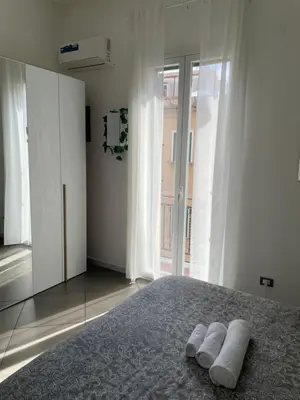 a white bedroom with two white towels on a bed at VITALENTA Palermo apartment in Palermo