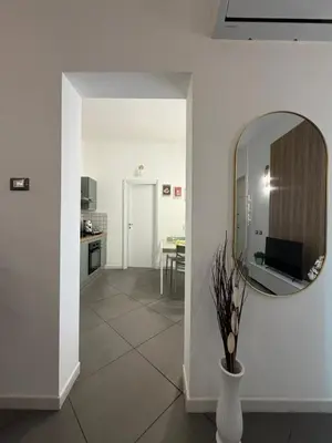 a room with a mirror and a vase with a plant at VITALENTA Palermo apartment in Palermo