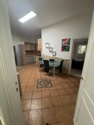 a room with a table and chairs and a kitchen at Fabian Appartament in Bagheria