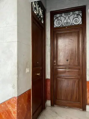 a wooden door is next to a wall at Dimora Blu in Palermo