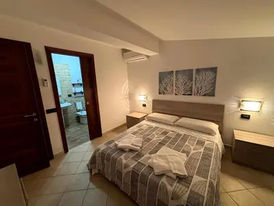 a bedroom with a bed with two towels on it at casa 3 nodi in Carini