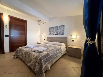 a bedroom with a bed and a wooden door at casa 3 nodi in Carini