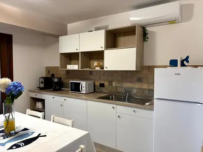 a kitchen with white cabinets and a white refrigerator at casa 3 nodi in Carini