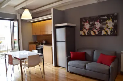 a kitchen and a living room with a table and a couch at New Palermo Holidays Penelope in Mondello