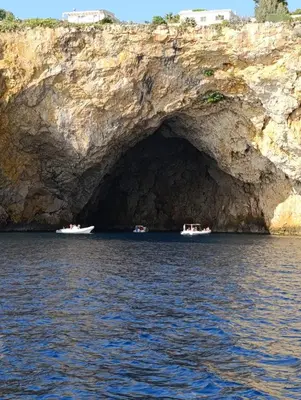 three boats in front of a cave in the water at AmarMare Bed&Breakfast in Trappeto