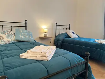 a bedroom with a bed and a table with a bottle of wine at Casa Verdi in Corleone