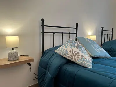 a bedroom with a bed with blue pillows at Casa Verdi in Corleone