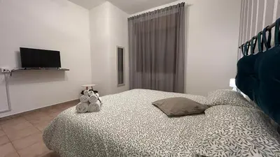 a bedroom with a bed and a table and a tv at Casa Verdi in Corleone