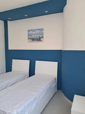 two beds in a room with a car on the wall at Al ventitré Home in Trabia