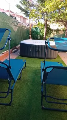 two chairs and a table in a yard with a trampoline at Al ventitré Home in Trabia