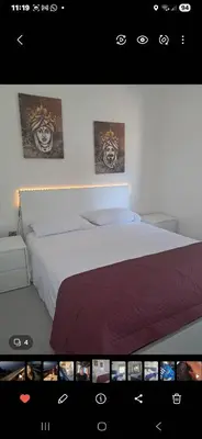a bedroom with a bed with two pictures on the wall at Al ventitré Home in Trabia